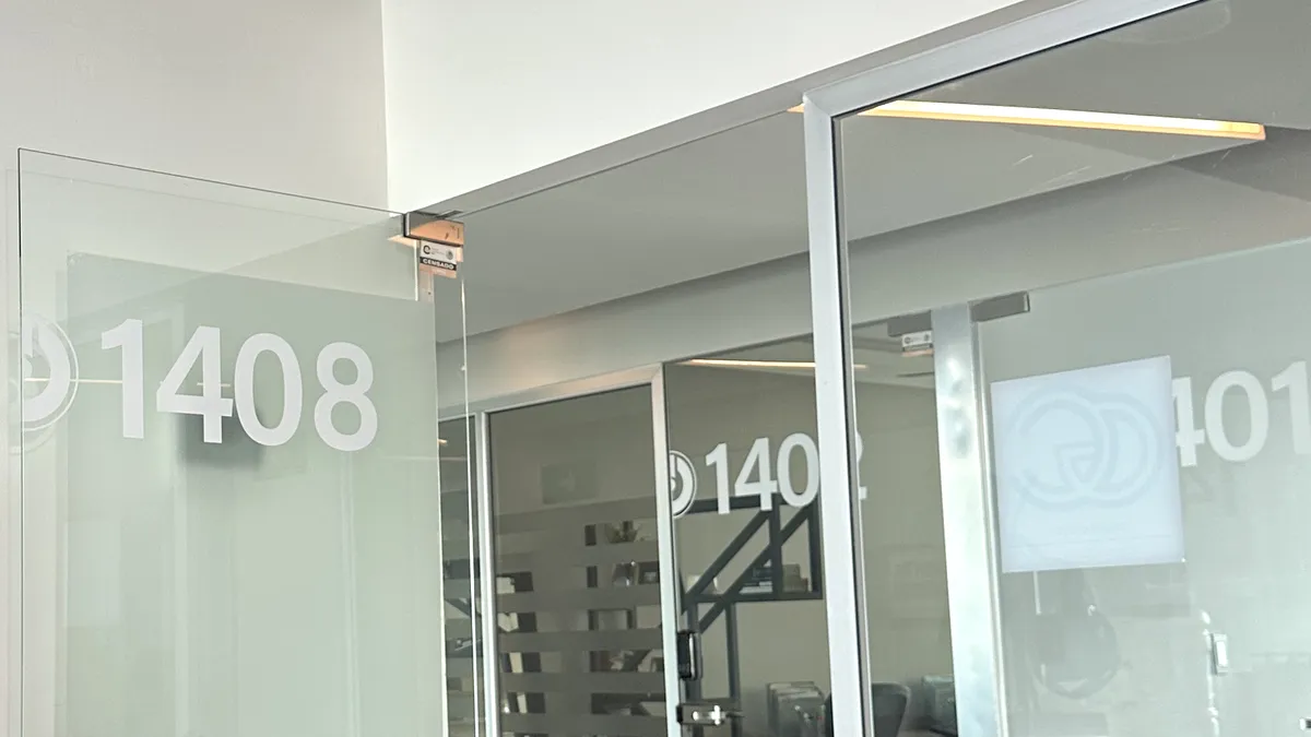 Entrada de la oficina 1408 de Grupo CerVel, con el logotipo del despacho en el cristal